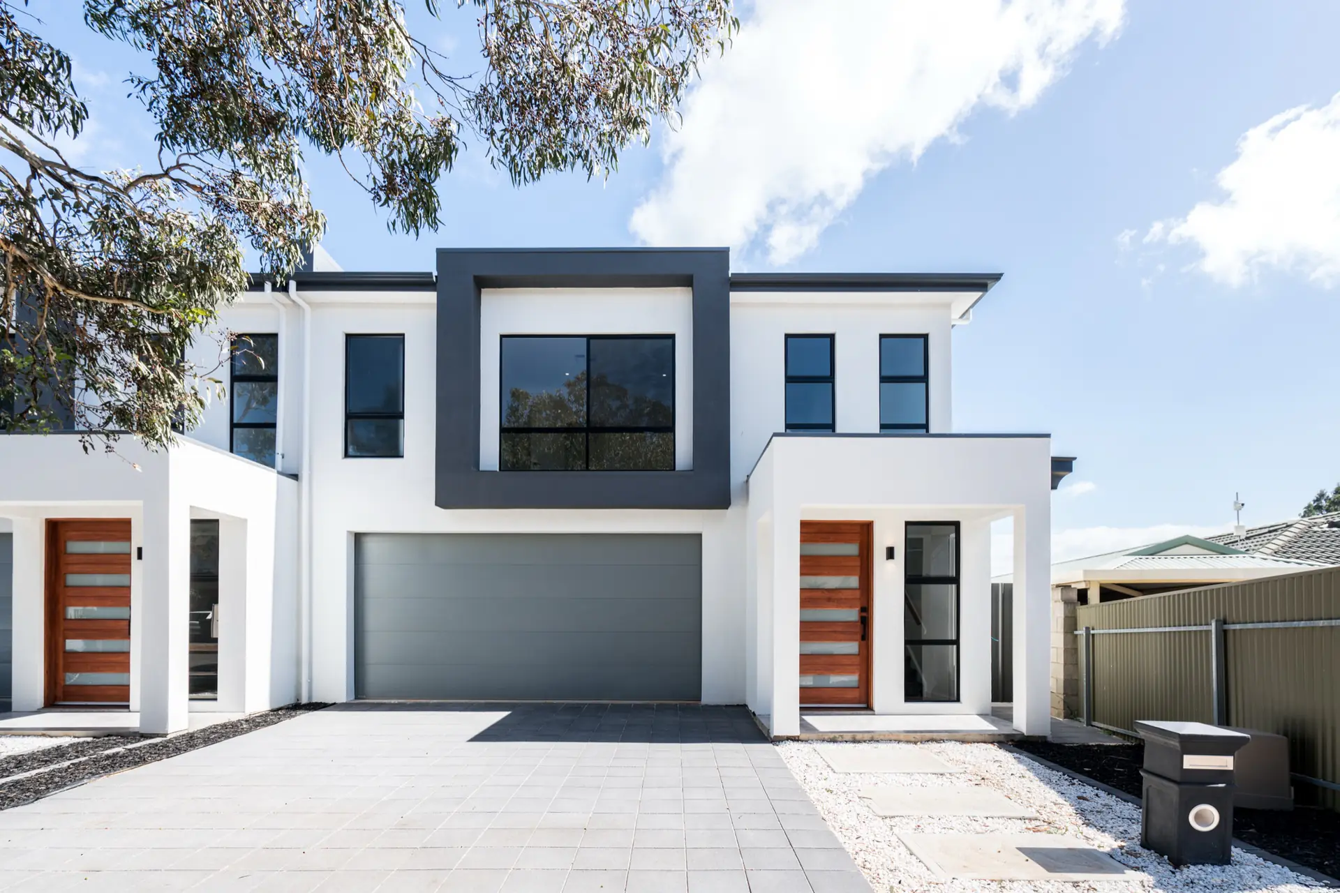 Limbert Avenue Seacombe Gardens residence with white render, charcoal framing and timber entry doors.