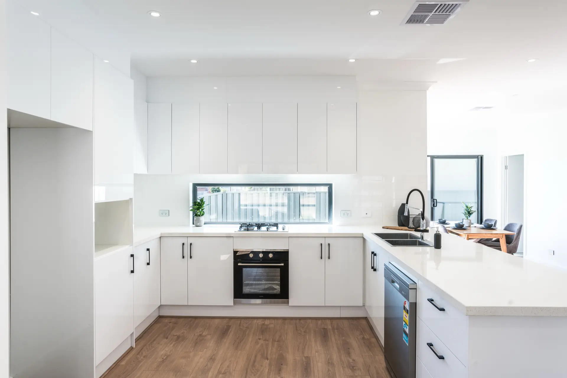 Limbert Avenue Seacombe Gardens kitchen with white cabinetry and black fixtures.