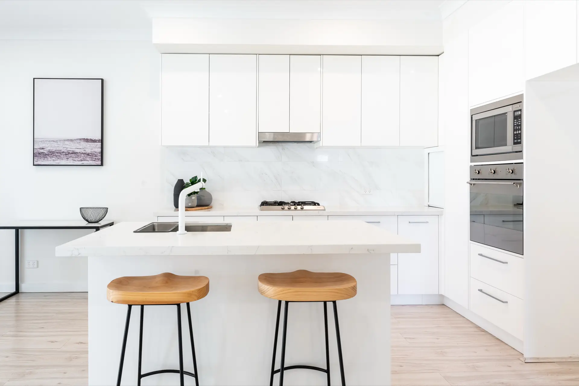 White kitchen at Strathcona Avenue Clapham with island bench and timber stools.