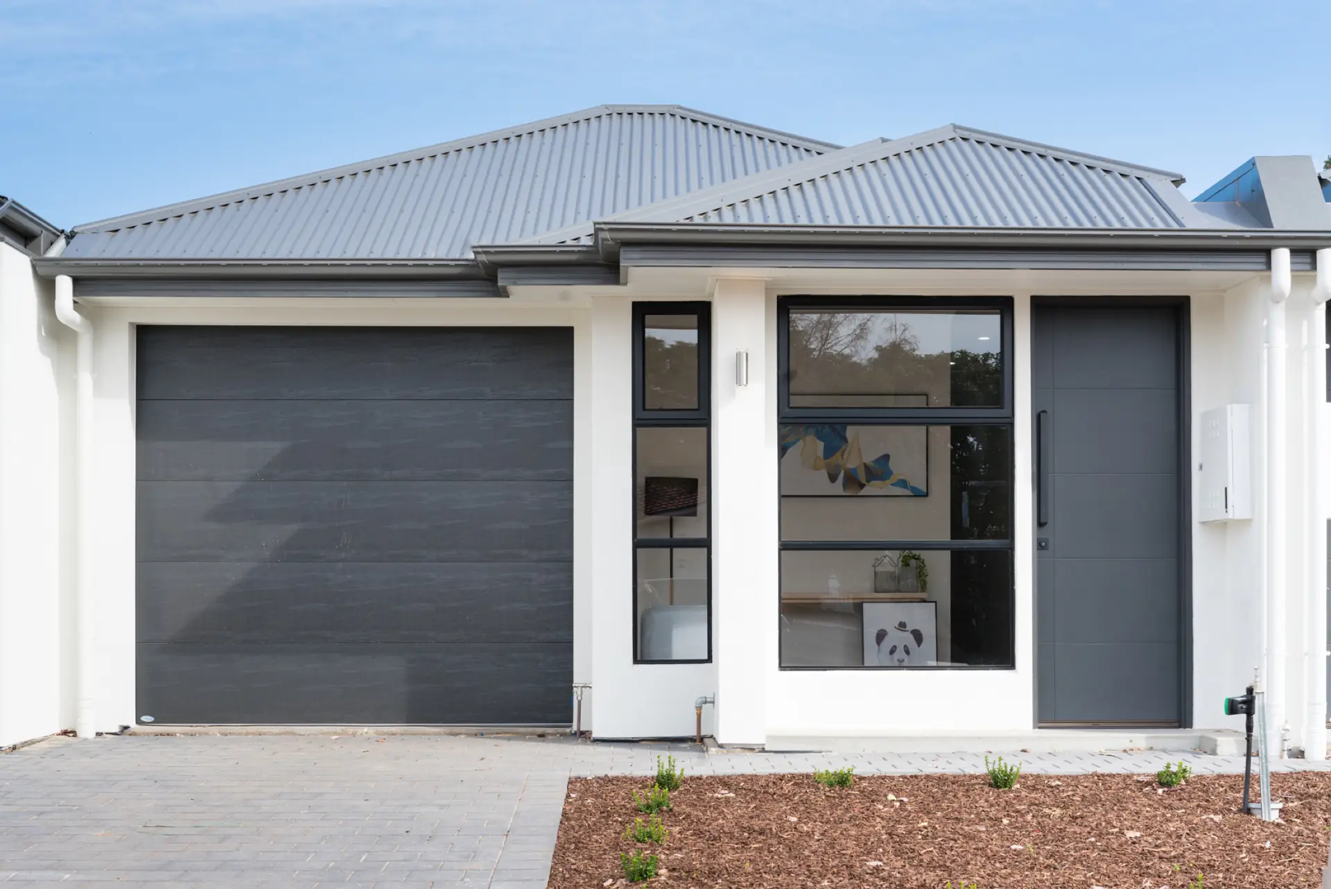 Waterhouse Road South Plympton residence with dark garage door, white render and black-framed glazing.